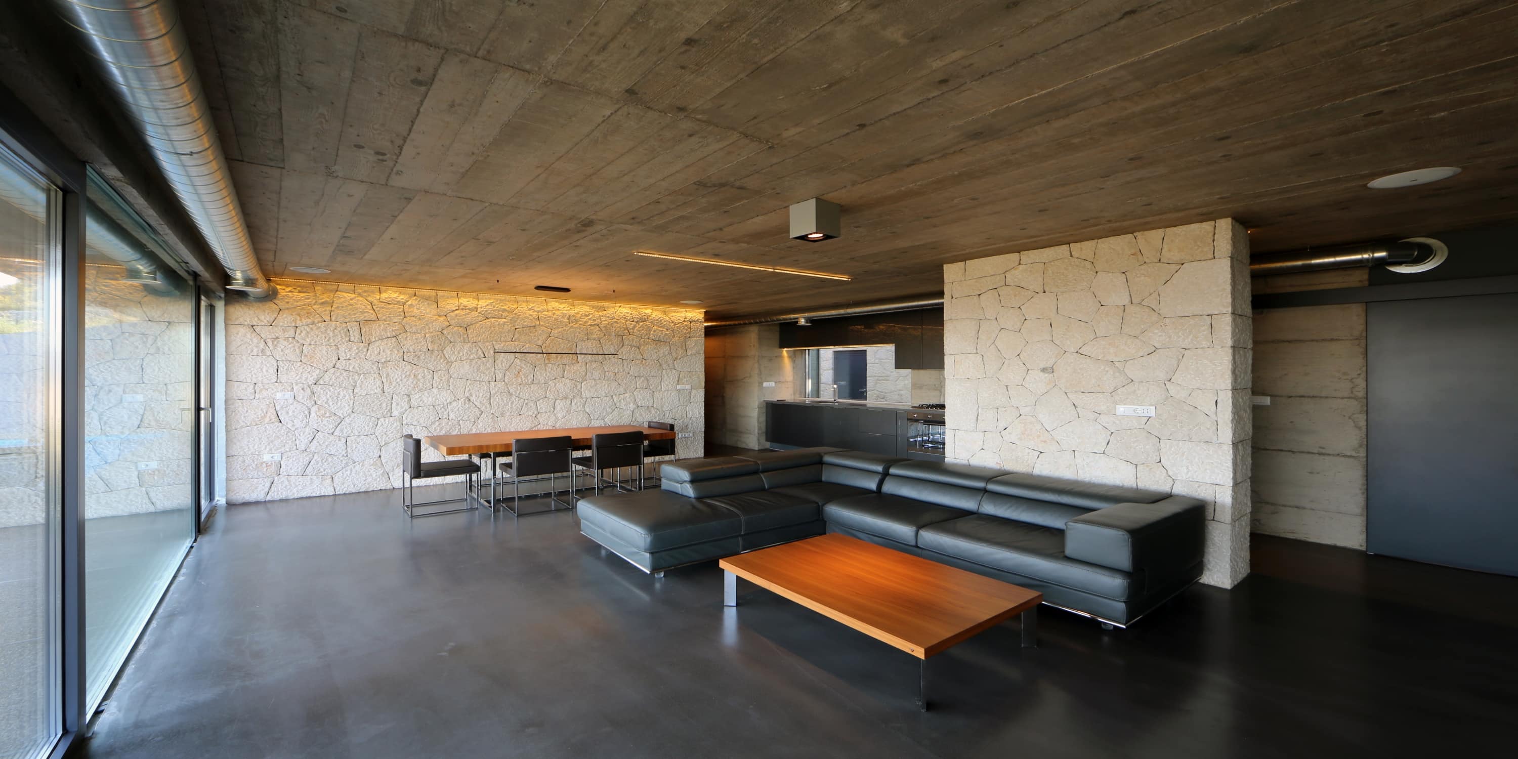 strakke woonkamer met donkere betonvloer